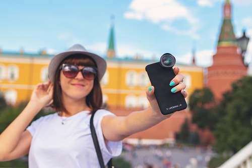 person woman holding smartphone with clip lens accessories