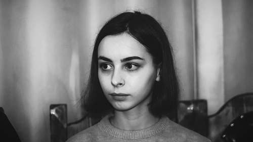 black-and-white woman in crew-neck top sitting on chair face