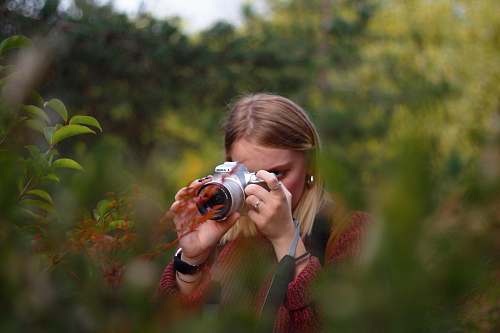 person woman taking photo using DSLR camera camera