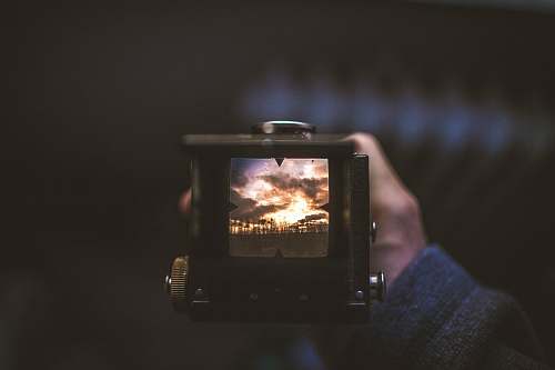 landscape selective focus photography of person holding camera trees