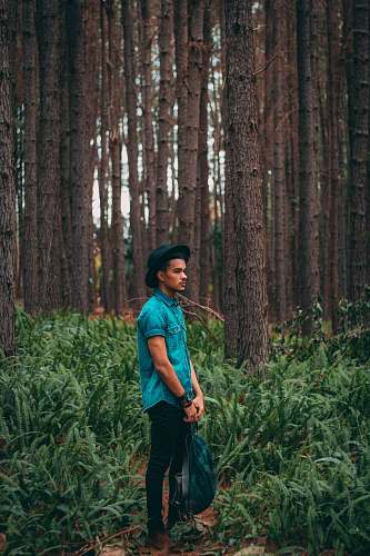 person man standing in the middle of forest during daytime human