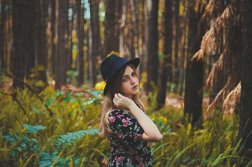 human woman standing near green grass and trees at daytime girl