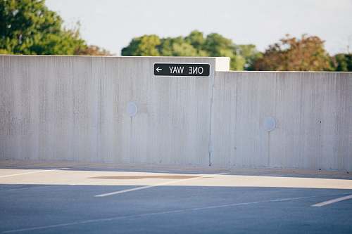 sign black and white one way signage on gray concrete wall one way