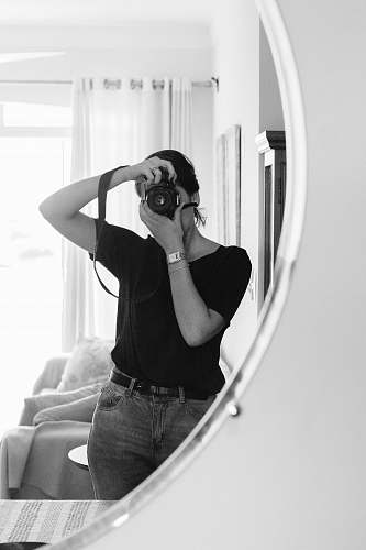 black-and-white greyscale photo of woman taking photo on mirror human