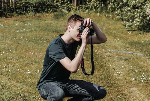 human man holding black DSLR camera photographer