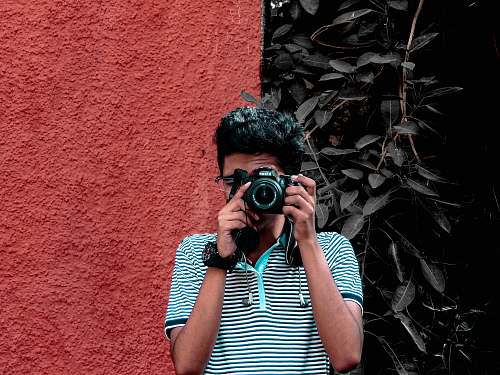 human man holding camera during daytime camera
