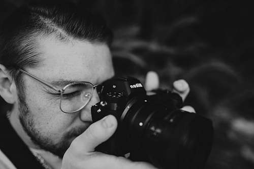black-and-white man holding DSLR camera human