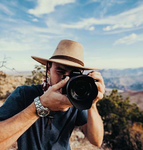 human man holding DSLR camera camera