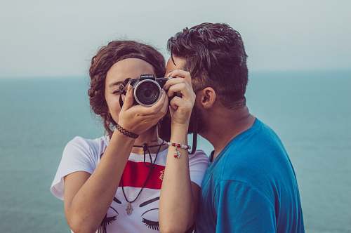 human man kissing woman's cheek while taking photo tunisie