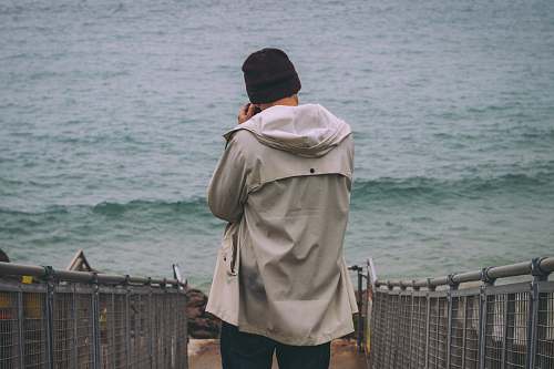 people person standing on pathway near sea beach