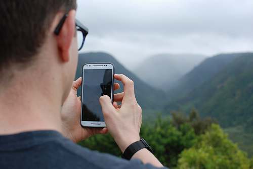 phone person taking photo of hills during daytime cell phone