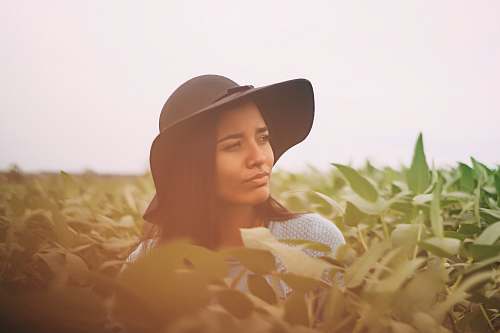 human photo of a woman taking a photo in the middle of green leaves woman