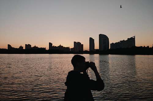 human silhouette of person using binoculars photographer