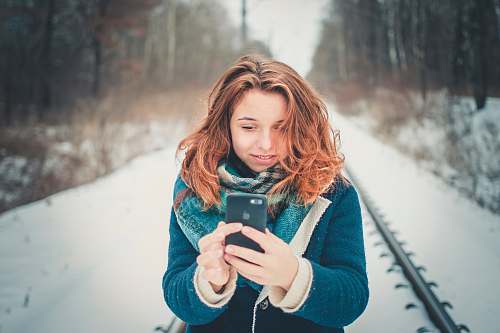 human woman holding phone standing on trail photo
