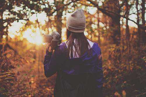 girl woman in forest holding DSLR camera during golden hour human