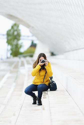 human woman sitting on stair and capturing photo apparel