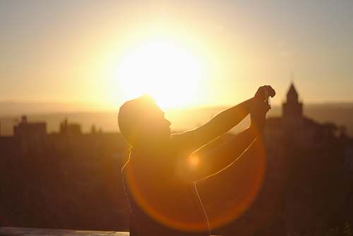 alhambra man raising hands under sunset granada