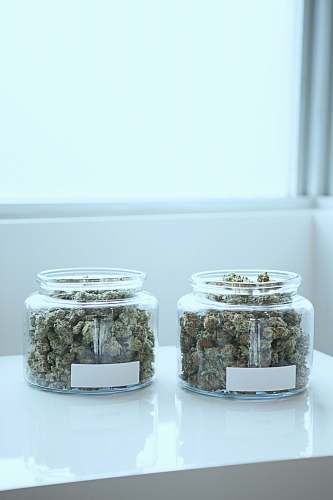 weed full of kush in clear glass jars on table jar
