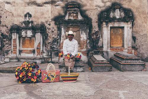 person man sitting on tombstone people