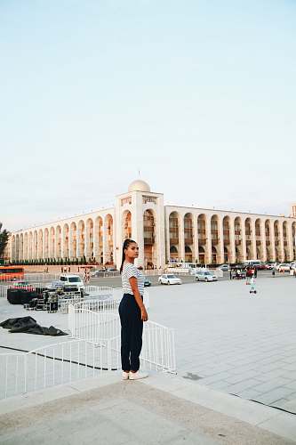 human woman standing front of concrete building at daytime building