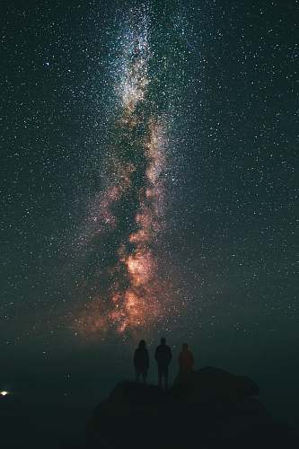 night three person looking stars and milky way sky
