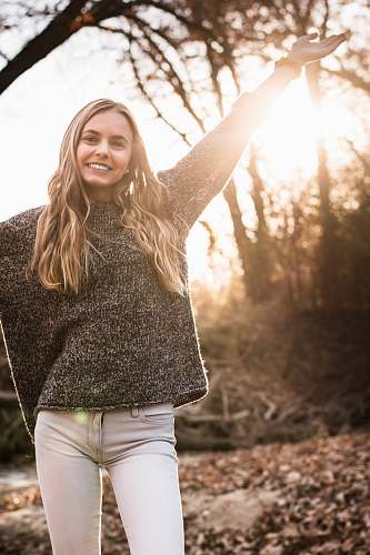 clothing woman raising right hand during daytime flare