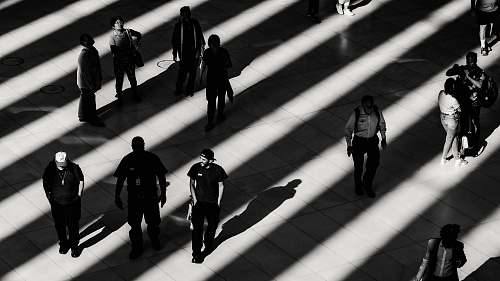 walking grayscale photo of people on white pavement railing