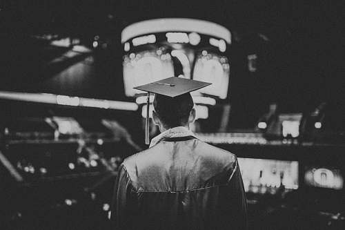 graduation man in academic dress wearing mortar cap grey