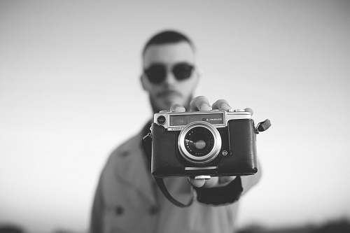 person man standing and showing bridge camera black-and-white