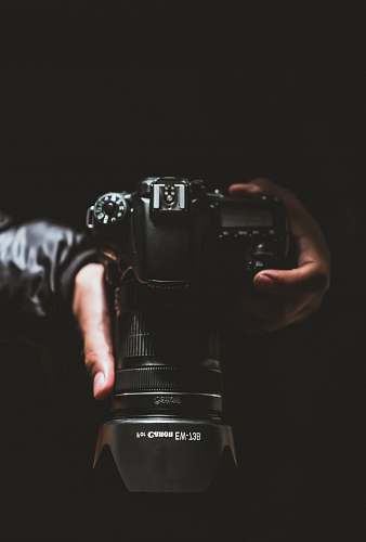 electronics person holding black Canon DSLR camera photo