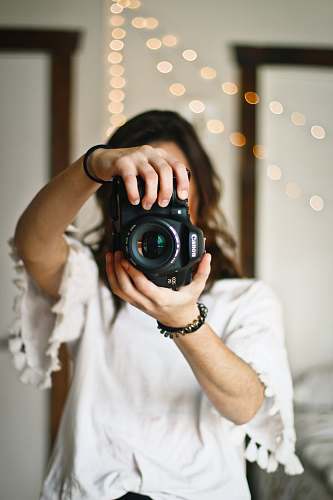person woman holding black DSLR camera human