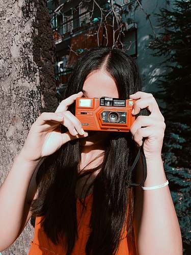 person woman holding orange camera human