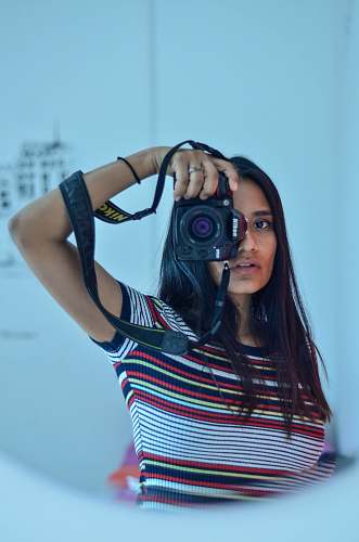 human woman in striped t-shirt holding camera person
