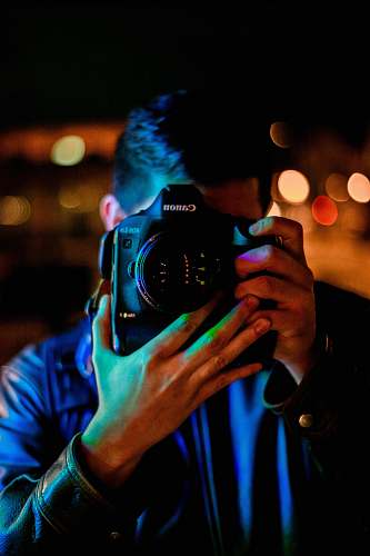 human man taking a photo using black Canon DLSR camera person