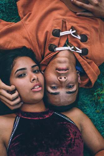 person man and woman lying down in grass face