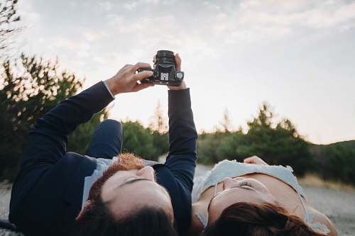 person man and woman lying on ground camera