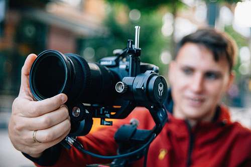 person man holding black Canon DSLR camera \during daytime camera