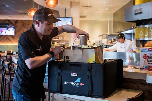 person man putting cup into brown bag apparel