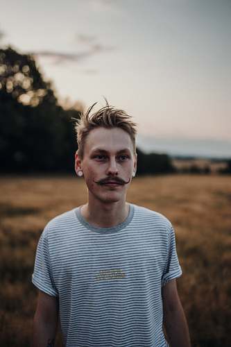 person man standing near trees at daytime apparel