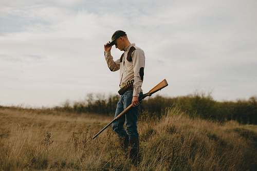 person man standing while holding shotgun photo