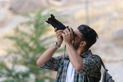 person man using DSLR camera photo