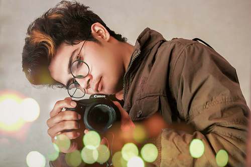person person holding Canon camera photographer
