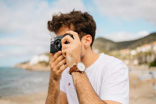 person shallow focus photography unknown person using black camera outdoors camera