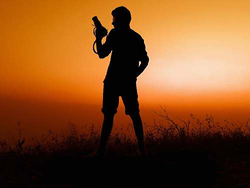 person silhouette of man holding pistol photo