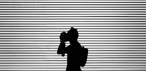 person silhouette photography of person wearing bag black-and-white