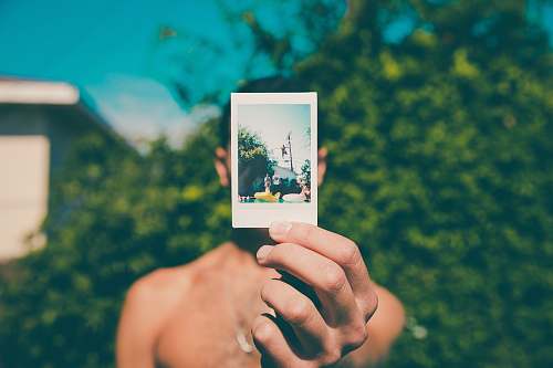 person topless man holding photo of person diving on pool selective focus photography photo