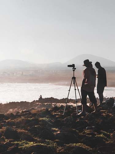 person two person standing in front of camera across mountain tripod