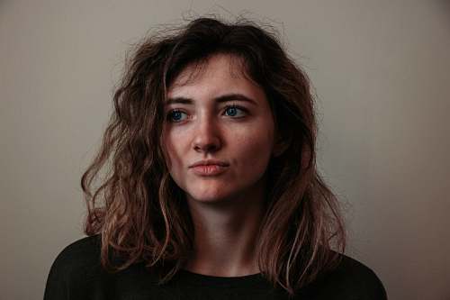 person woman standing beside wall face
