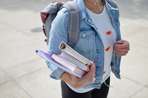 school woman wearing blue denim jacket holding book people