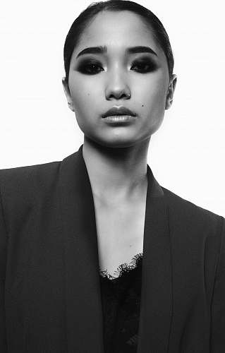 black-and-white woman wearing shawl lapel blazer in grayscale poster face